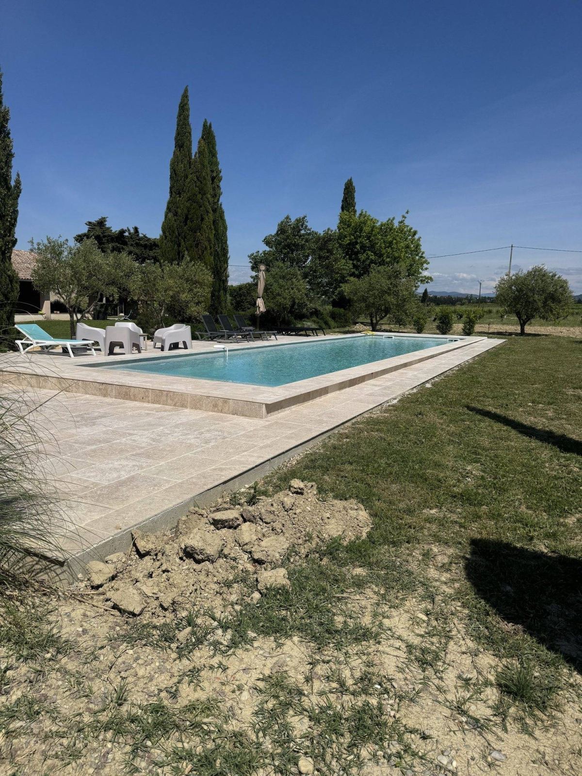 Vue d’ensemble d’une piscine découverte et de son espace extérieur.