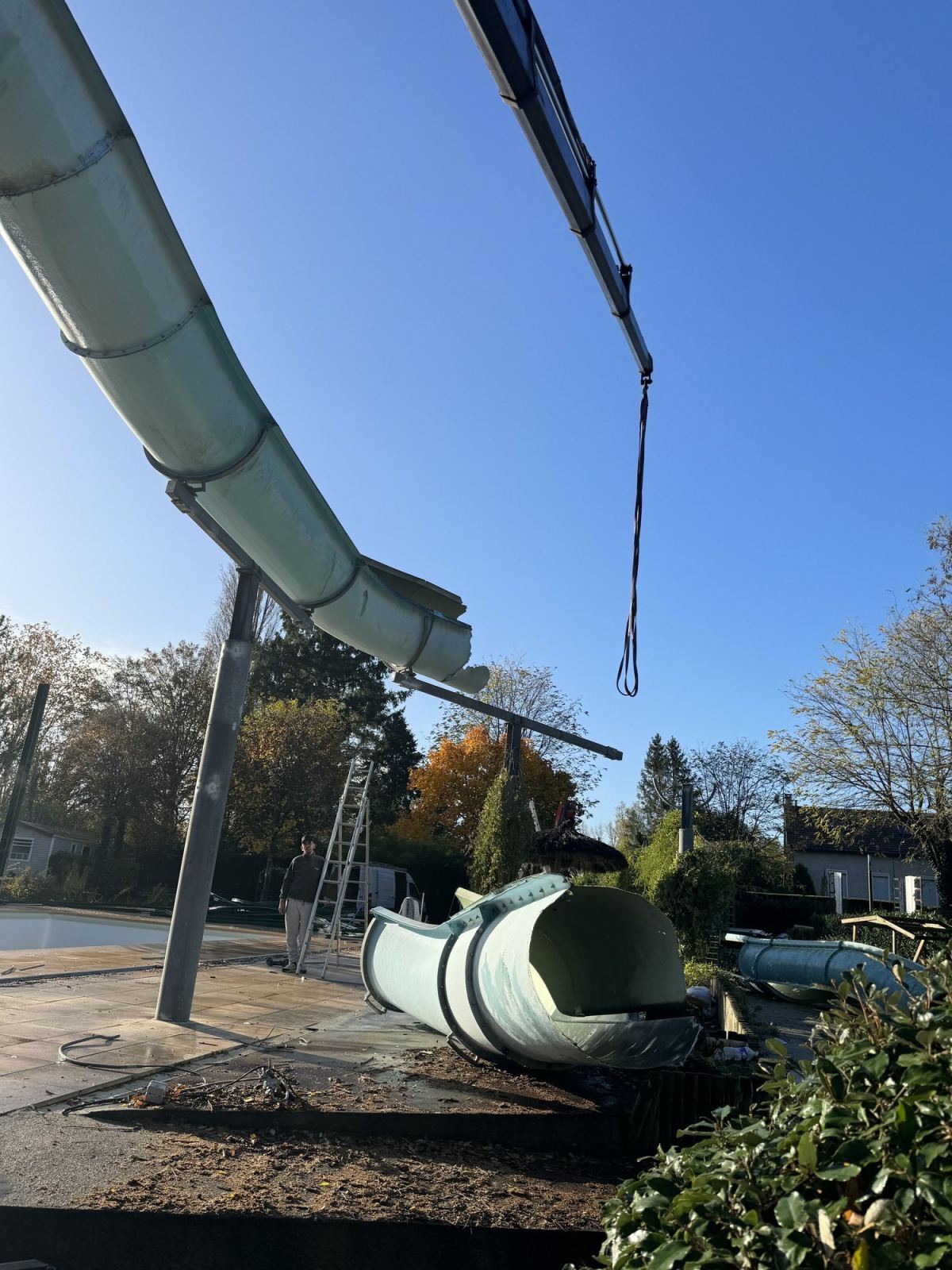 Un tronçon de toboggan et une grue sur le chantier de dépose.