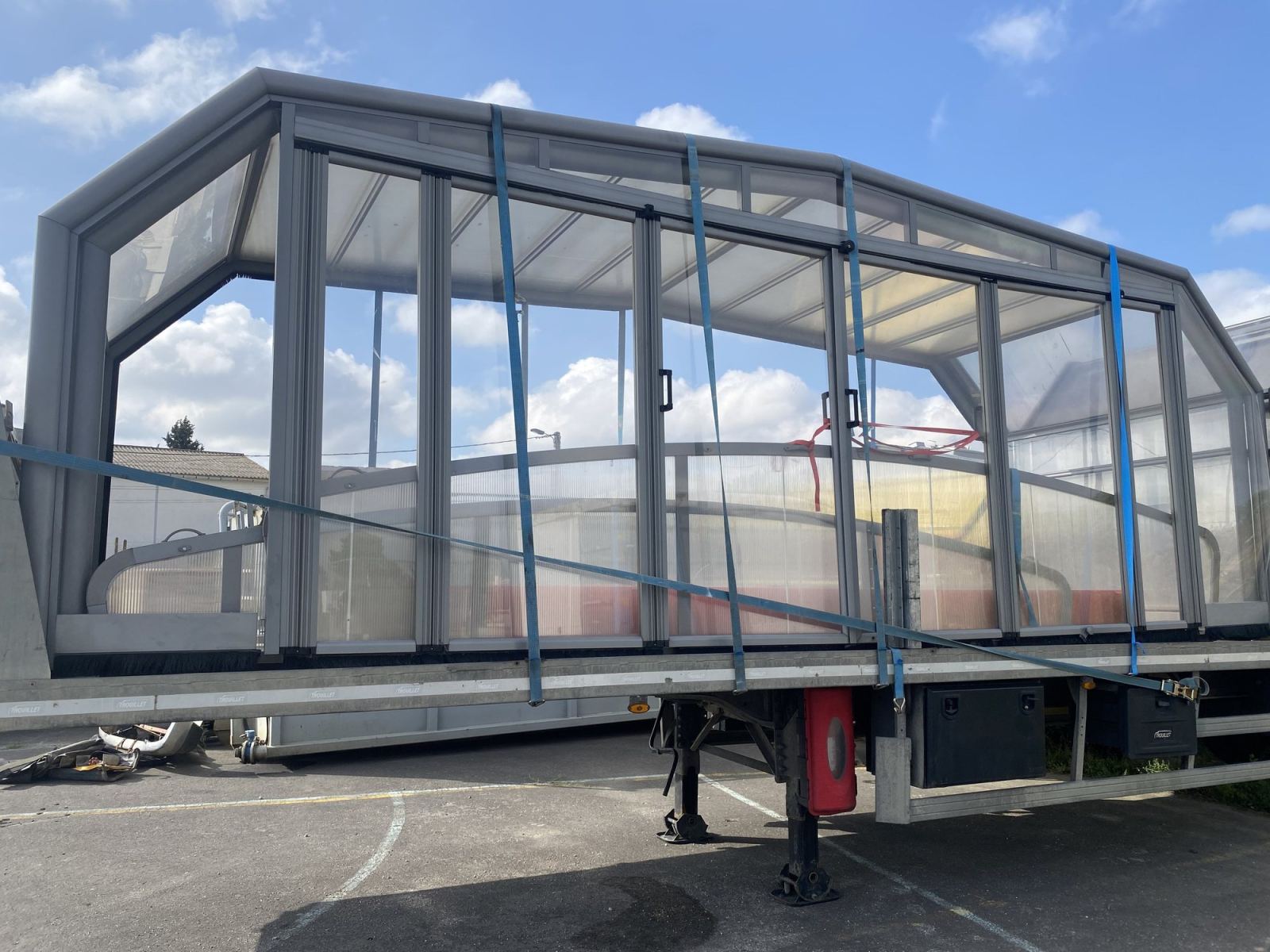 Module vitré d’abri de piscine arrimé sur une remorque.