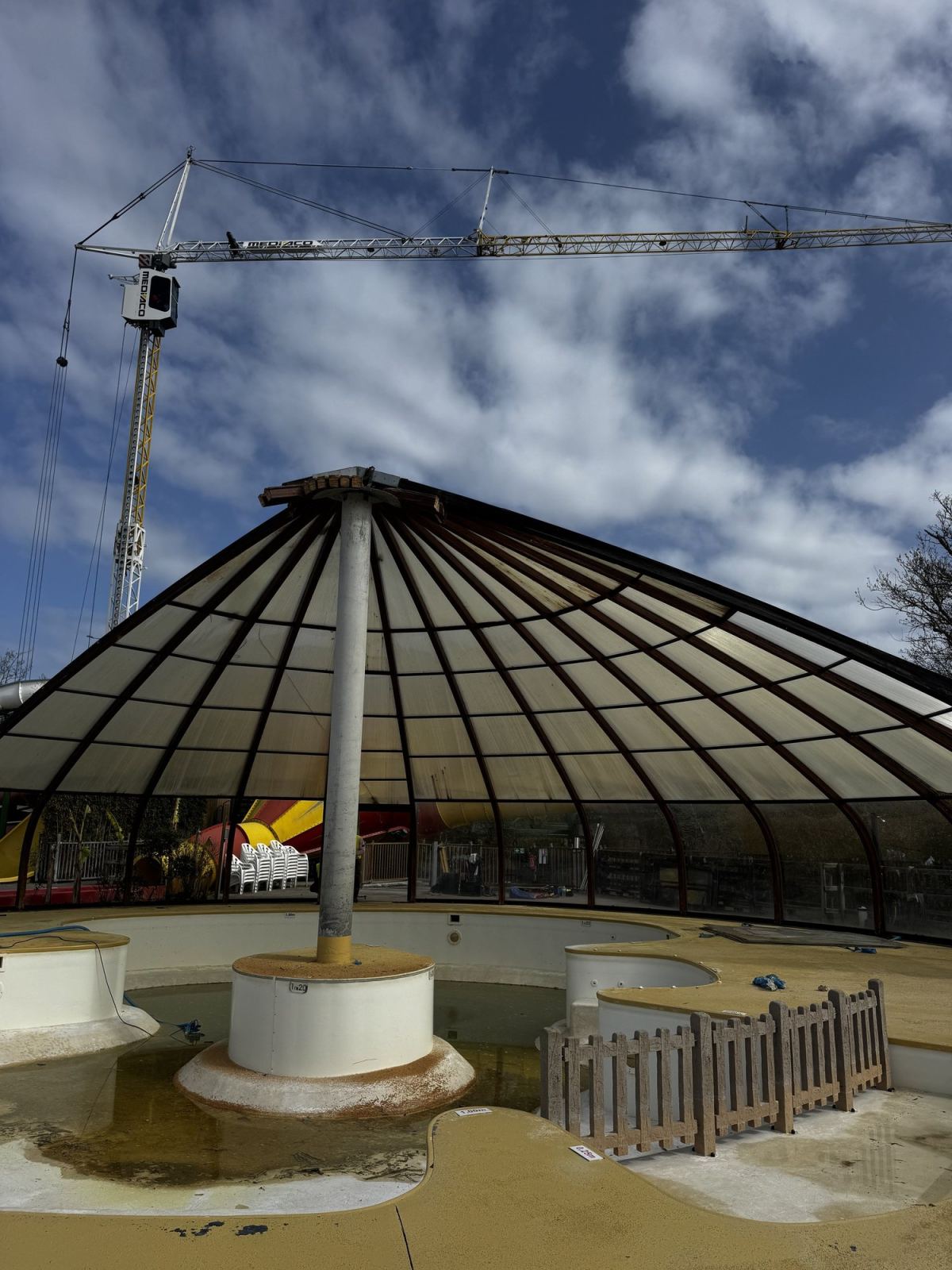 Grue et intervenants travaillent sur la toiture de l’abri circulaire.