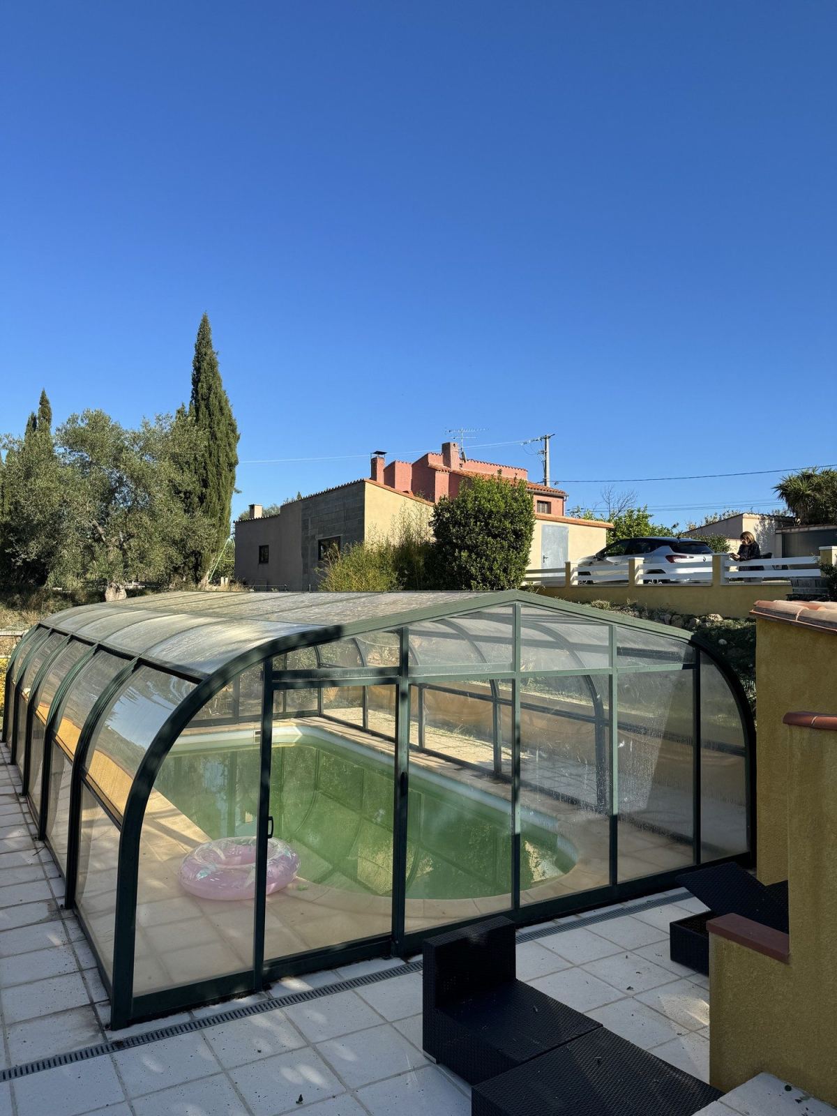 Modules cintrés de l’abri au bord de la terrasse d’une piscine privée.