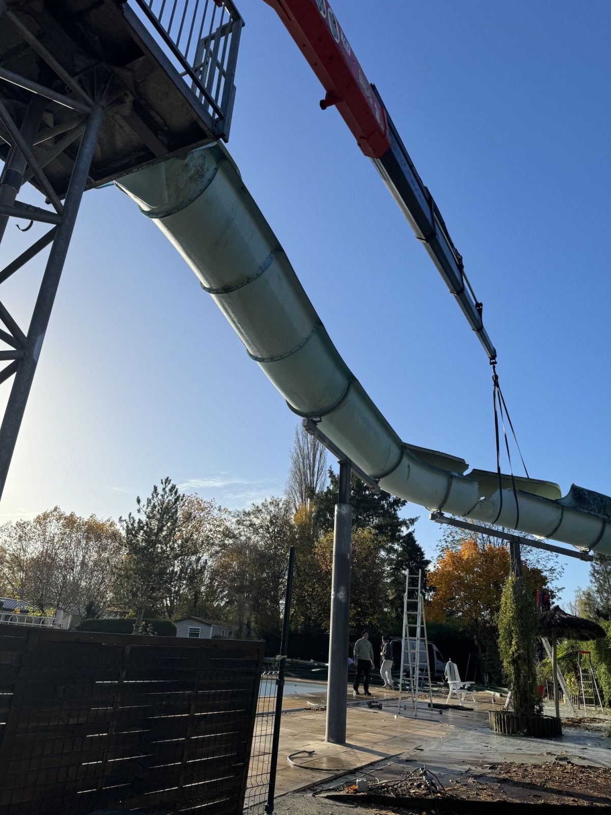Une grue intervient au-dessus du toboggan pendant la dépose d’un tronçon.