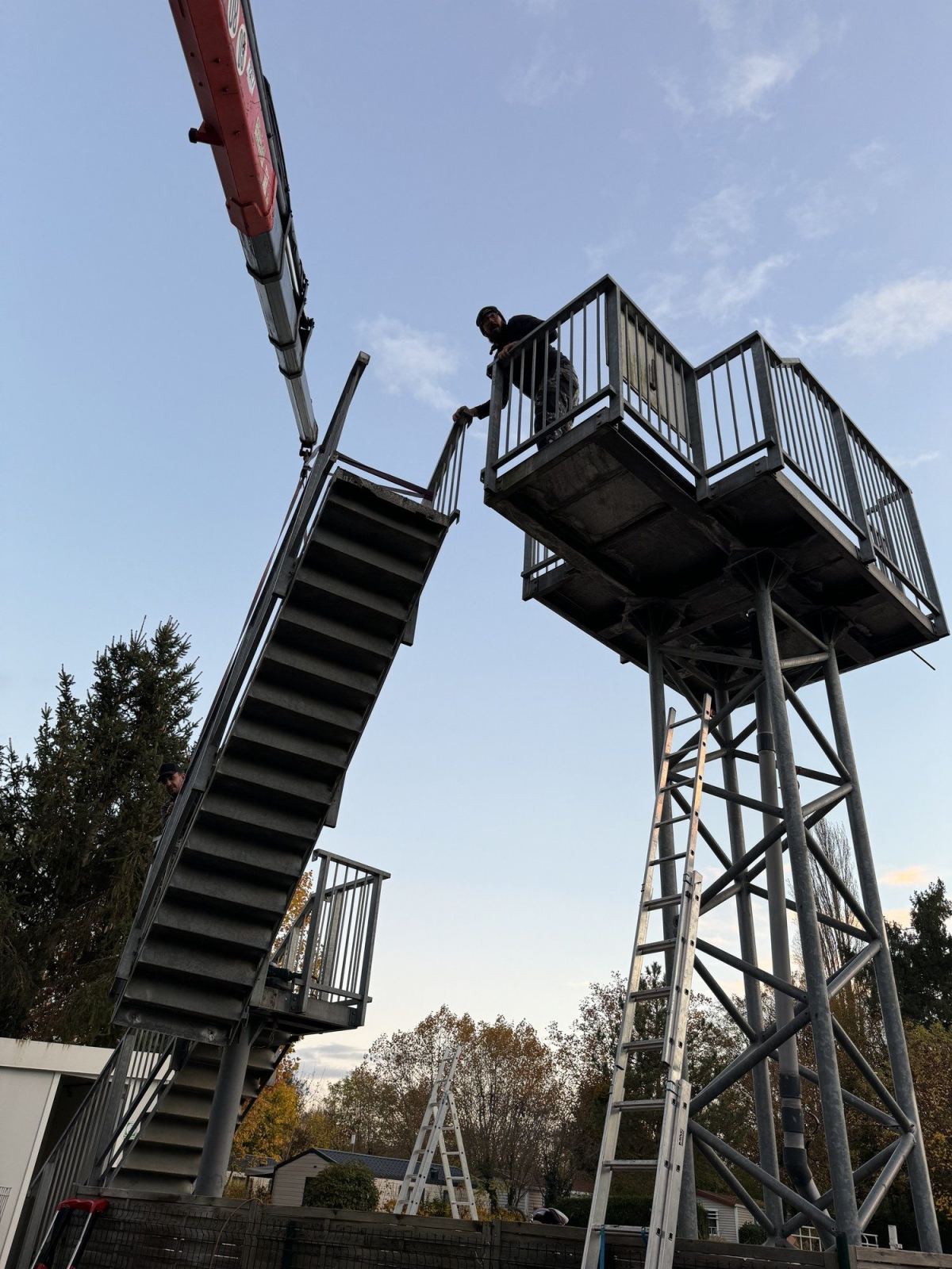 Escalier et plateforme métalliques du toboggan soulevés à la grue.