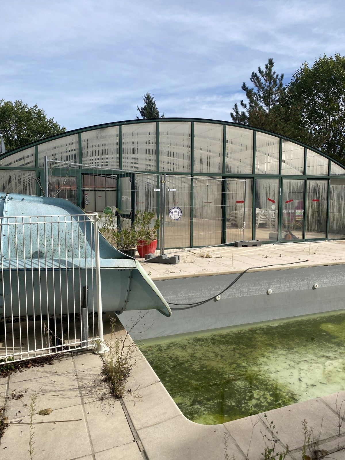 Grand abri de piscine collectif à proximité de toboggans aquatiques.