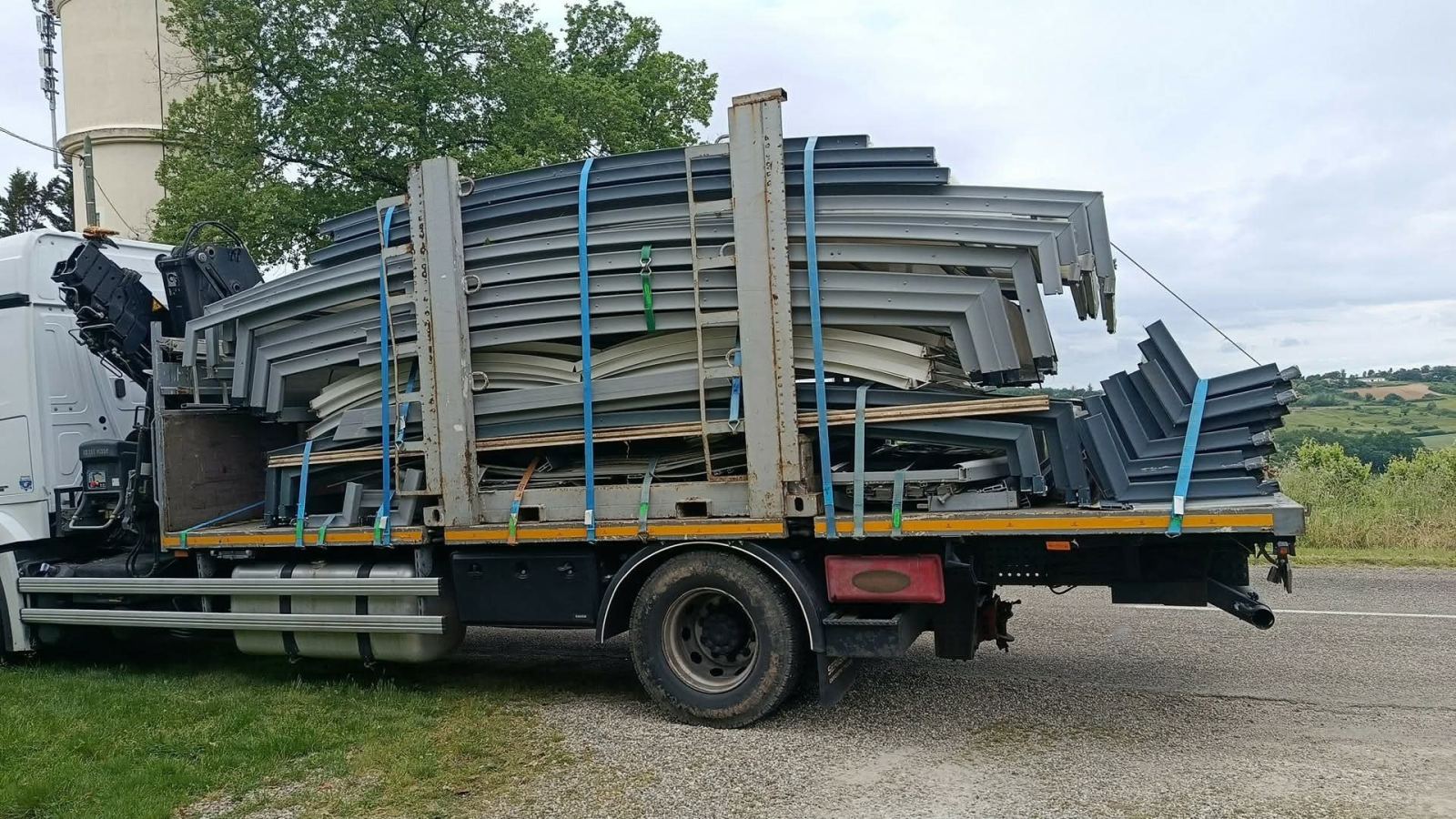 Vue latérale du camion transportant les éléments d’un abri démonté.